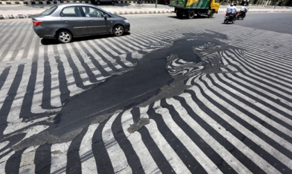 Road markings appear distorted as the asphalt starts to melt due to the high temperature in New Delhi, India, 27 May 2015. Photograph: Harish Tyagi/EPA 